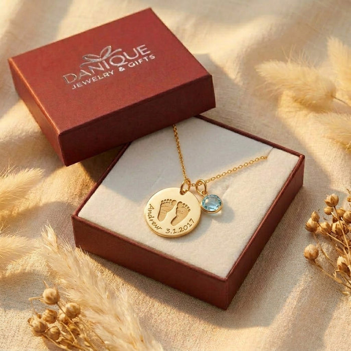 Gift-ready baby footprint necklace with birthstone charm displayed in Danique Jewelry box.
