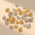 Hand stamped initial charms in gold and silver with leaf, bird, and heart shapes for adding a personalized charm to a necklace or bracelet.