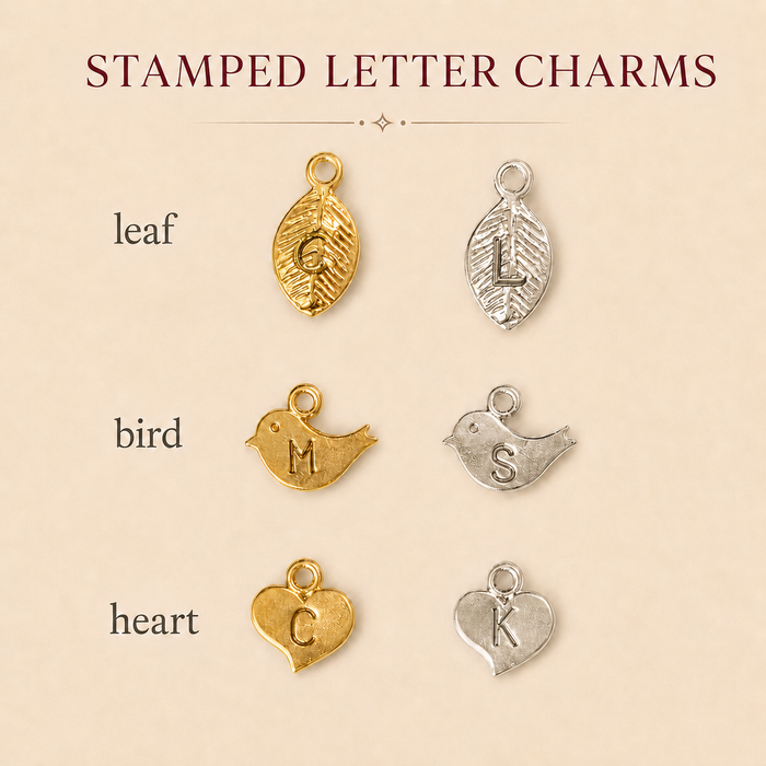 Stamped letter charm chart showing leaf, bird, and heart initial charm styles in gold and silver finishes.