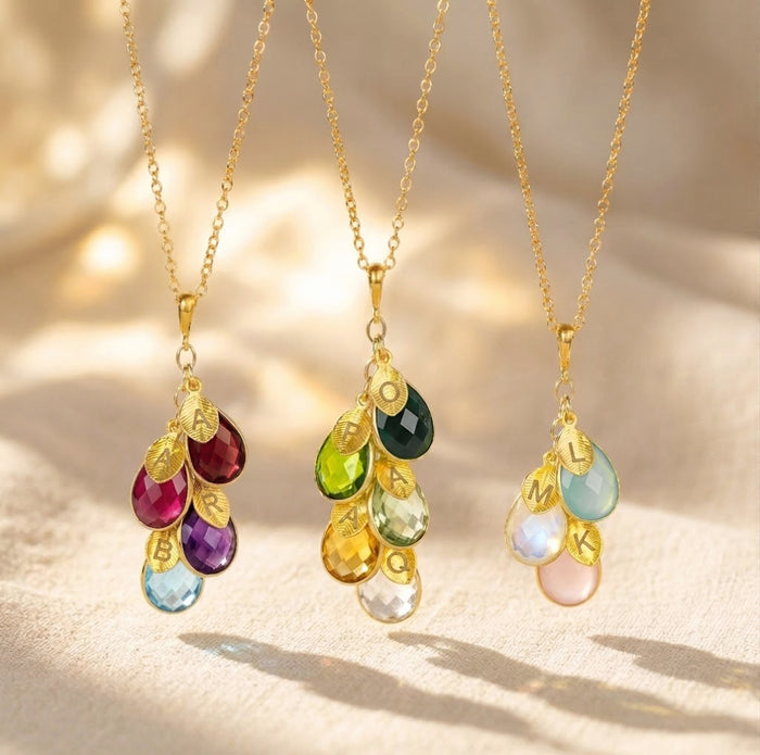 Family birthstone necklaces shown in gold and silver with colorful teardrop stones and initial charms, a meaningful custom necklace for mom or grandma.