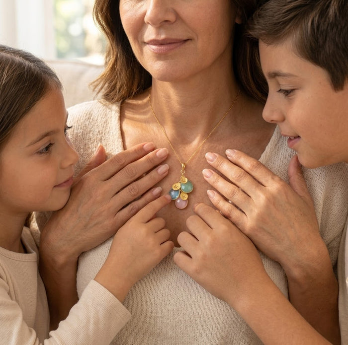 Model wearing personalized cascading birthstone necklace, a custom mother’s necklace with gemstone charms and initials for children or grandchildren.
