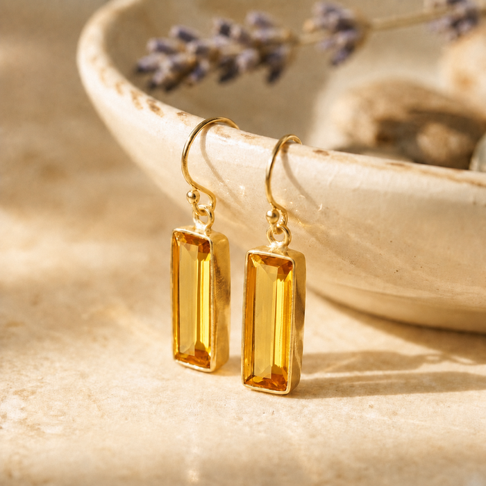 Citrine Quartz baguette drop earrings in yellow gold vermeil displayed on a cream ceramic dish
