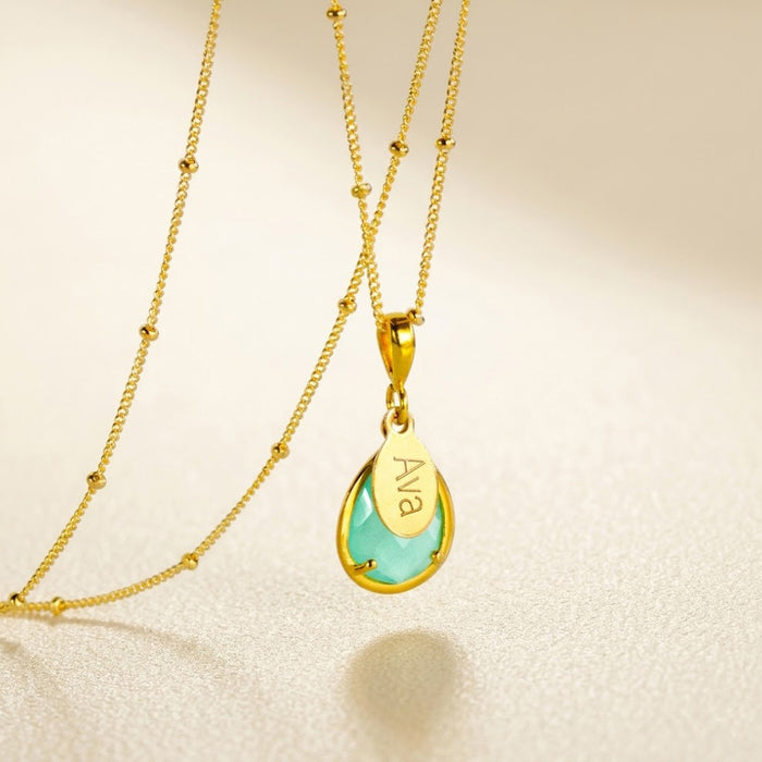 Personalized aqua chalcedony name necklace in gold with engraved oval charm and teardrop March birthstone pendant