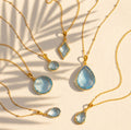 blue topaz necklace collection available in large, medium and small teardrops, prong set teardrop, prong set diamond, large and medium rounds on white background. Choose from satellite or cable chain. December birthstone.