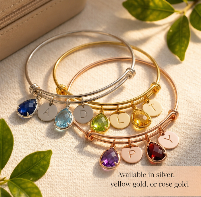 Birthstone initial bangle bracelet shown in silver, yellow gold, and rose gold finishes with custom charms.