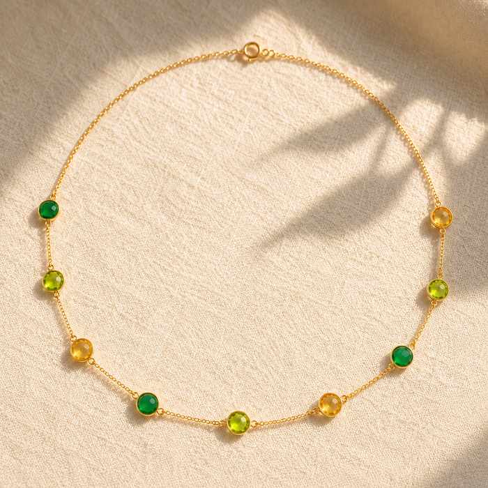 Custom birthstone station necklace with green and yellow natural gemstones spaced along a delicate yellow gold chain