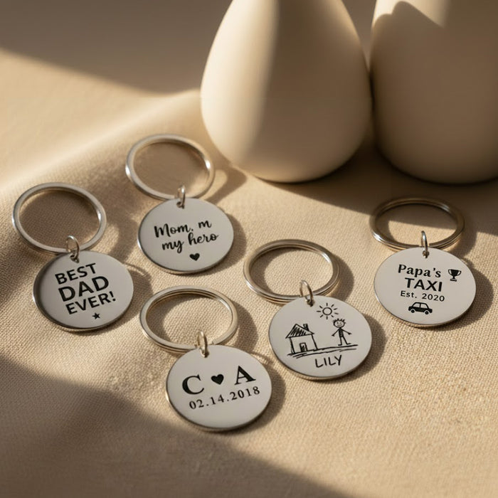 Custom engraved circle keychains displayed on neutral surface, featuring personalized names, dates, and short messages. Polished stainless steel round keychains designed as meaningful keepsakes for dads, moms, and family members. Personalized engraved keychain gifts perfect for Father’s Day, Mother’s Day, birthdays, anniversaries, or everyday reminders of love.