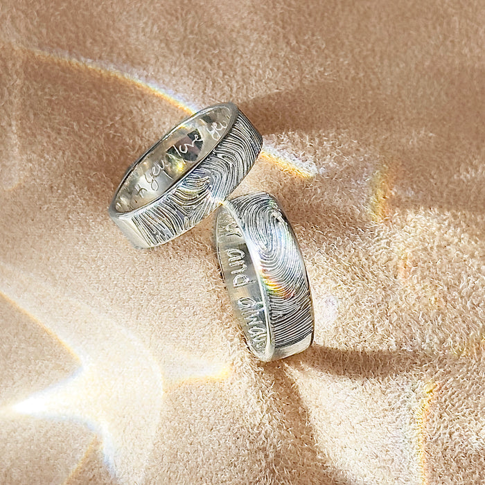 two sterling silver 6mm bands with fingerprint on the outside and handwriting on the inside. Gift for her, gift for him, memorial gift, commemorative gift, gift for fiance, gift for husband, gift for wife, gift for girlfriend, gift for boyfriend, silver anniversary gift, wedding gift, graduation gift, gift giving ready, christmas gift, valentine's day gift, birthday gift, family reunion gift, funeral gift, gift for those who lost loved ones, unique gifts for men, unique gifts for women. sterling silver band