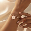 Custom pet bangle bracelet in gold showing engraved paw print and pet name on a polished disc charm, designed for dog moms and cat moms who want meaningful personalized jewelry. Adjustable wire bangle creates a comfortable everyday fit. Perfect as a sentimental pet memorial bracelet, birthday gift for pet lovers, or Christmas gift for women. Available in sterling silver, yellow gold, and rose gold finishes for a timeless keepsake accessory.