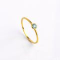 Single gold plated blue topaz dainty 3mm gemstone ring. December birthstone ring on white background.