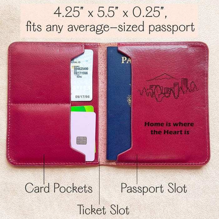 Open view of a red leather travel document holder featuring organized compartments including passport slot, ticket sleeve, and two card pockets. Size dimensions 4.25" x 5.5" x 0.25", compatible with most standard-sized passports. Stylish travel wallet engraved with a mountain skyline and the phrase “Home is where the Heart is.” Perfect for keeping travel essentials safe and accessible. Ideal jetsetter accessory, international travel organizer, boarding pass holder, and compact ID and credit card carrier.