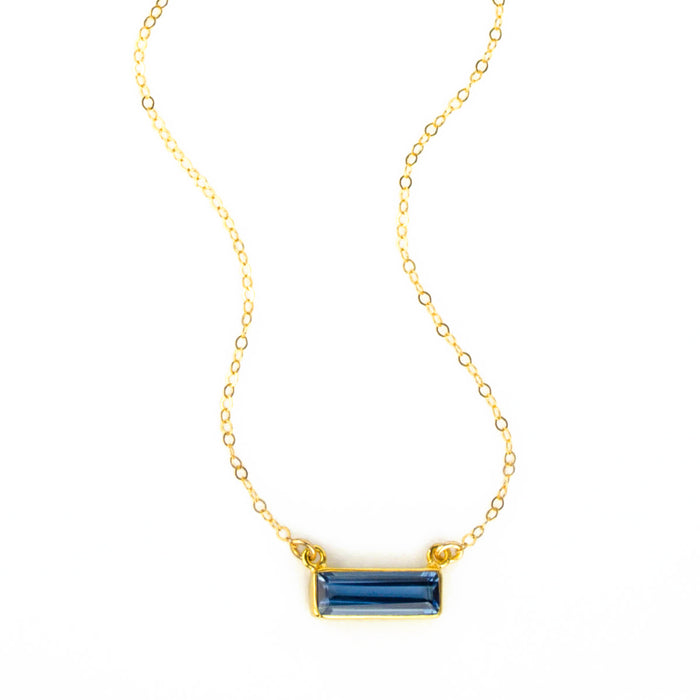 Single gold filled cable chain with horizontal september kyanite birthstone bar on white background