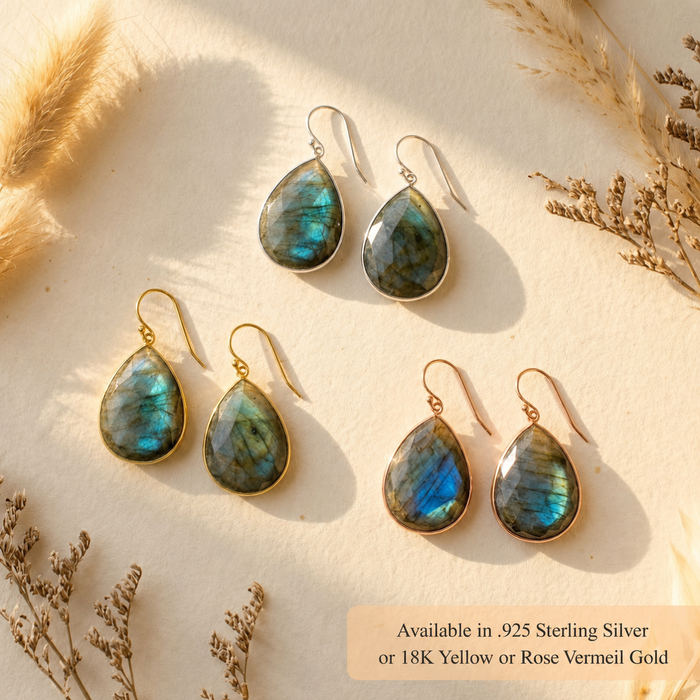 Labradorite earrings displayed with dried flowers in warm light, showing natural gemstone teardrops available in sterling silver or 18K vermeil gold.