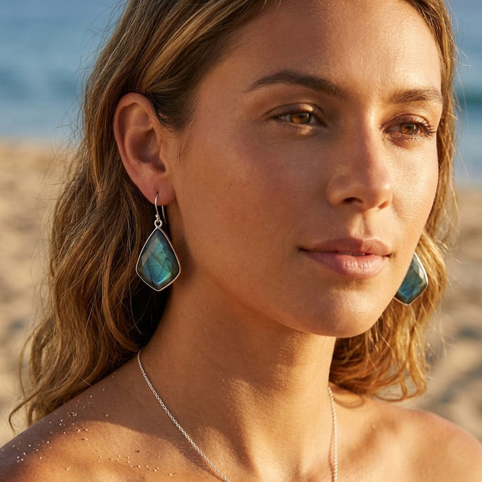 Natural labradorite earrings with blue green flash gemstone on a beautiful young model outside