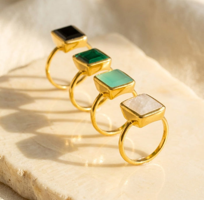 Aqua chalcedony and gemstone ring collection with black onyx, moonstone, emerald, and labradorite.