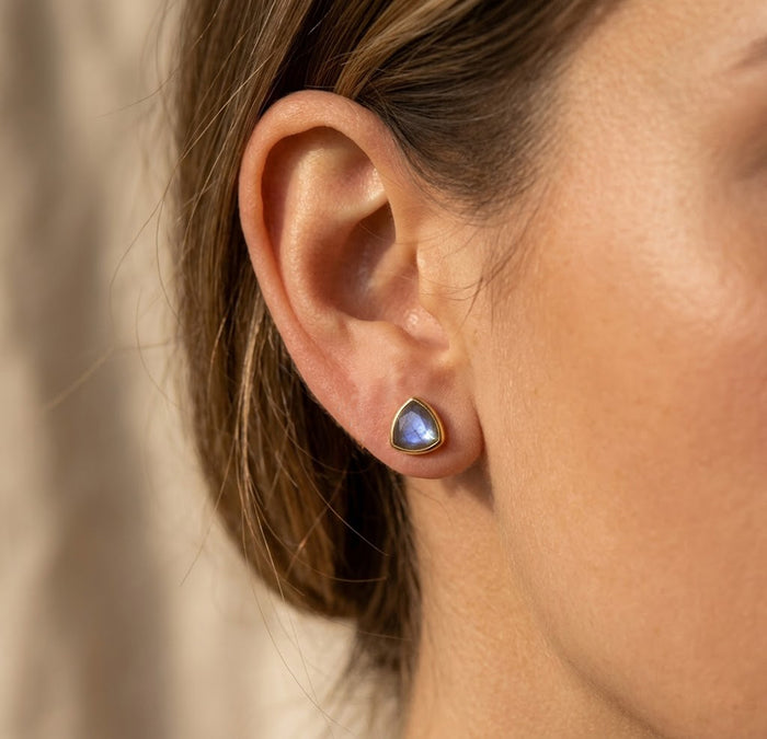Model wearing labradorite triangle stud earrings, showing petite gemstone stud scale and minimalist everyday style.