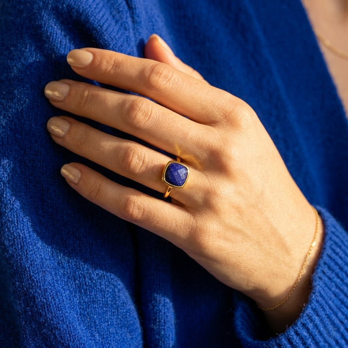 Hand wearing lapis lazuli cushion ring with gold bezel, deep blue gemstone ring for everyday wear or special occasions