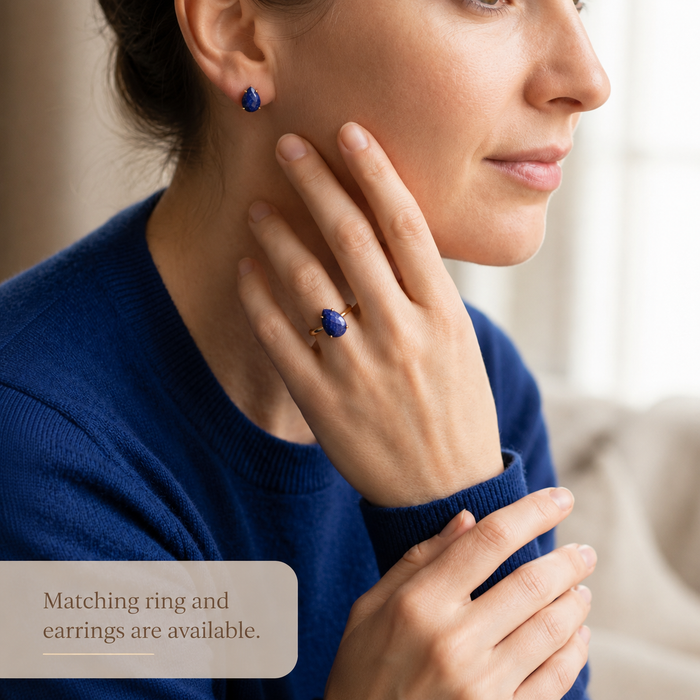 Woman wearing lapis lazuli ring and matching blue gemstone earrings, styled as a coordinated birthstone jewelry set.