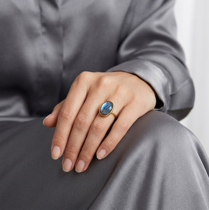 Model wearing labradorite ring with gray outfit, a natural oval gemstone ring for everyday statement jewelry.