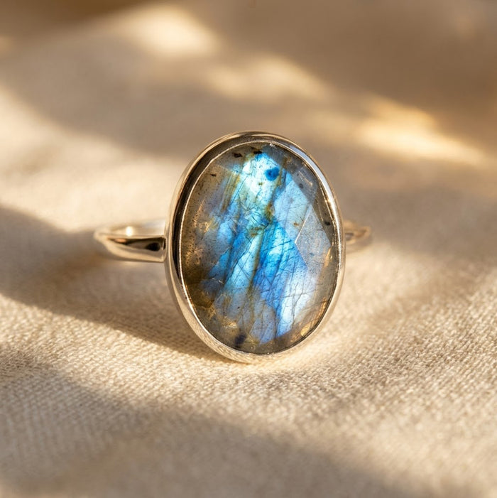 Close-up of oval labradorite ring in gold vermeil, showing natural stone variation and blue iridescent flash.