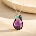 Mom birthstone necklace with large purple teardrop stone and two small kids birthstones in silver