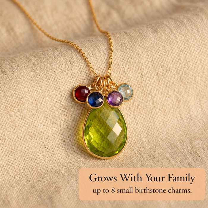 Gold mom birthstone necklace with large green teardrop stone and four small birthstones