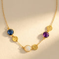Mom necklace with custom birthstones and initial charms in gold on beige background