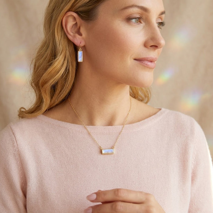Model wearing a moonstone bar necklace with matching moonstone earrings, styled as elegant June birthstone jewelry.
