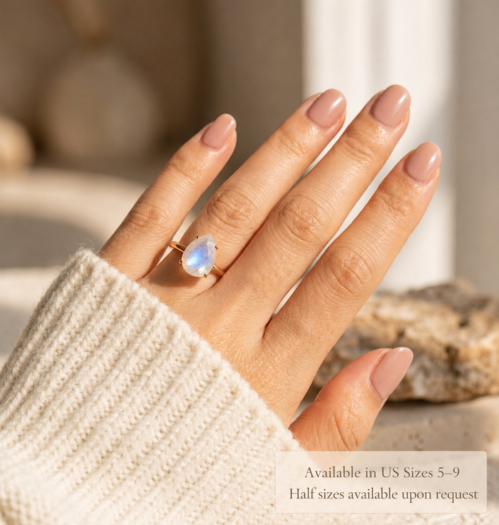Moonstone ring and matching moonstone stud earrings worn by model in warm sunlight