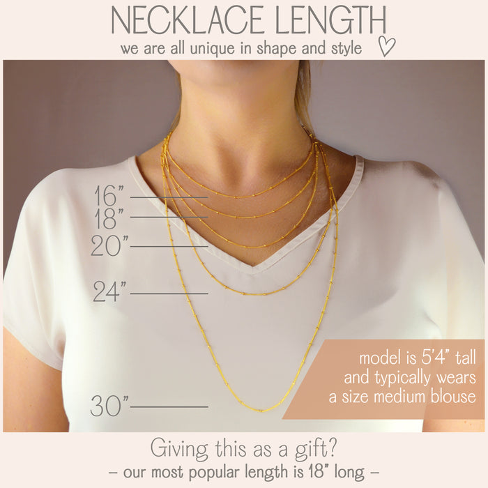 A woman wears multiple satellite chains to showcase our variety of chain lengths. Available lengths range from 16 inches to 30 inches