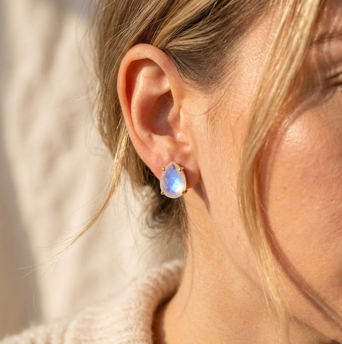 Model wearing natural rainbow moonstone stud earrings, showing the delicate teardrop size and soft iridescent glow for everyday gemstone jewelry.