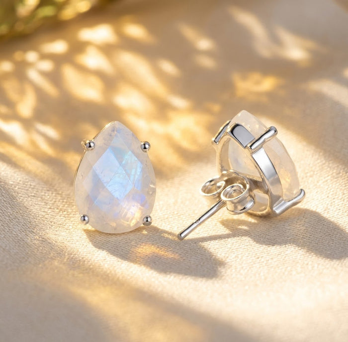 Rainbow moonstone teardrop stud earrings shown in sterling silver, featuring natural iridescent gemstones with a soft luminous glow.