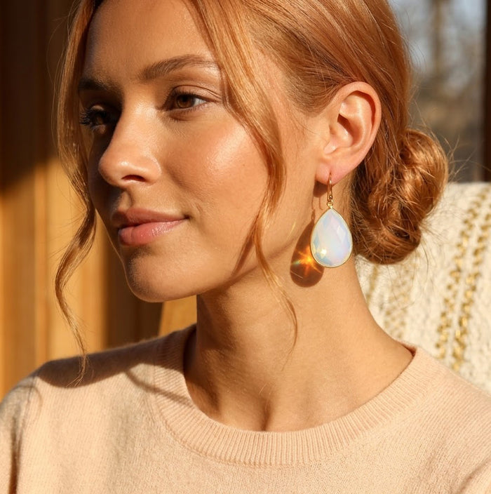 Model wearing opalite teardrop earrings with a soft cream sweater for an elegant everyday jewelry look.