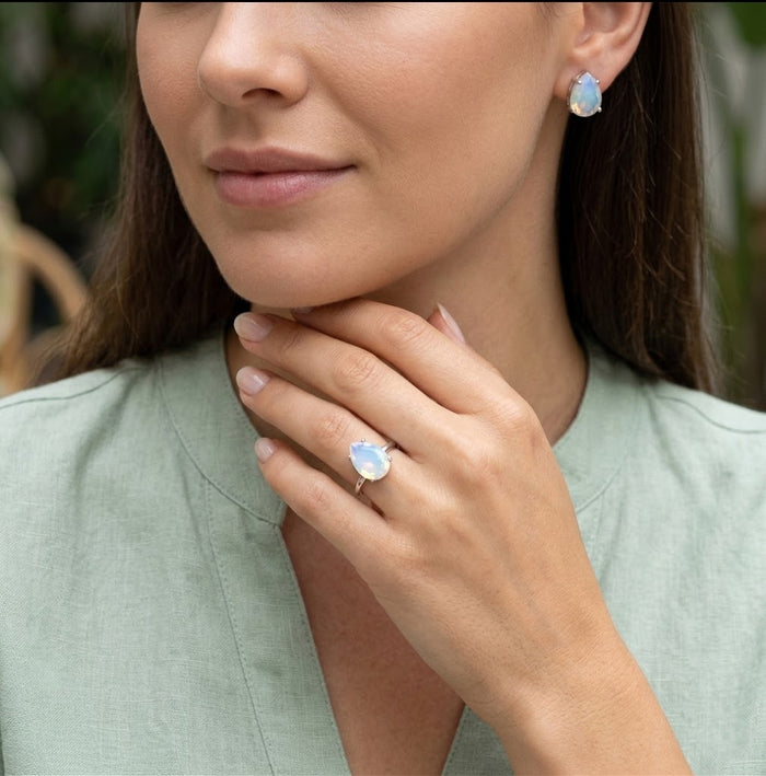 Model wearing a rose gold opalite birthstone ring, a delicate pear-shaped gemstone ring for October birthdays and everyday jewelry.