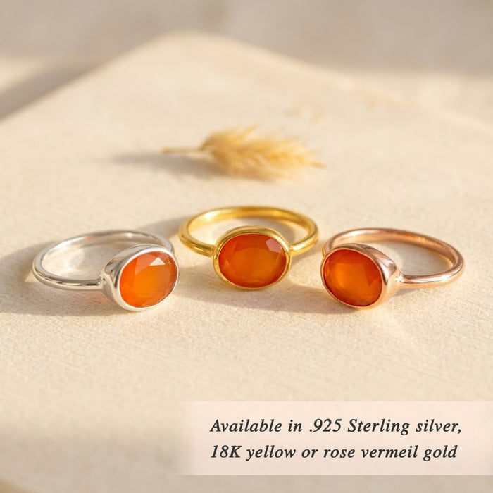 Three oval carnelian rings with orange gemstones shown in sterling silver, yellow gold vermeil, and rose gold vermeil finishes.