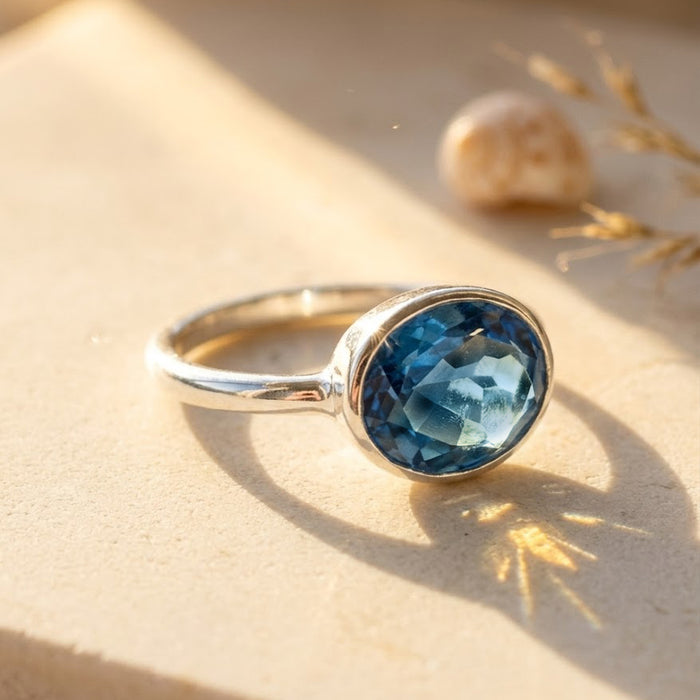Sterling silver kyanite ring featuring an oval, sapphire-blue faceted stone in a sleek bezel setting; modern minimalist profile ideal for stacking; durable .925 band, hypoallergenic, and a chic September birthstone alternative to sapphire.