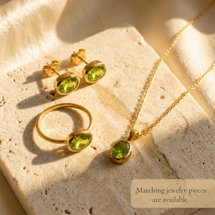 Matching peridot jewelry pieces including oval peridot ring, necklace, and stud earrings in gold.