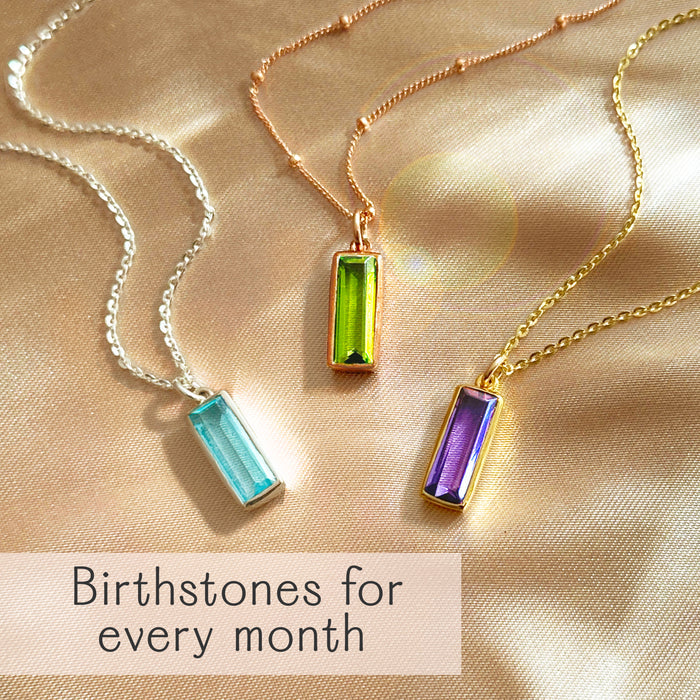 Baguette birthstone necklaces in .925 sterling silver and 18K vermeil (yellow/rose), shown with aquamarine March, peridot August, and amethyst February stones. Minimalist bar pendant, option for custom engraving—birthstones for every month.