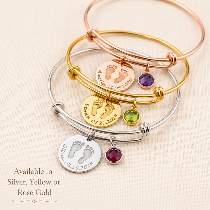 Personalized baby footprint bangle bracelets in silver, yellow gold, and rose gold with engraved discs and birthstone charms.