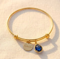 Personalized birthstone bangle bracelet with engraved name disc charm and blue teardrop stone