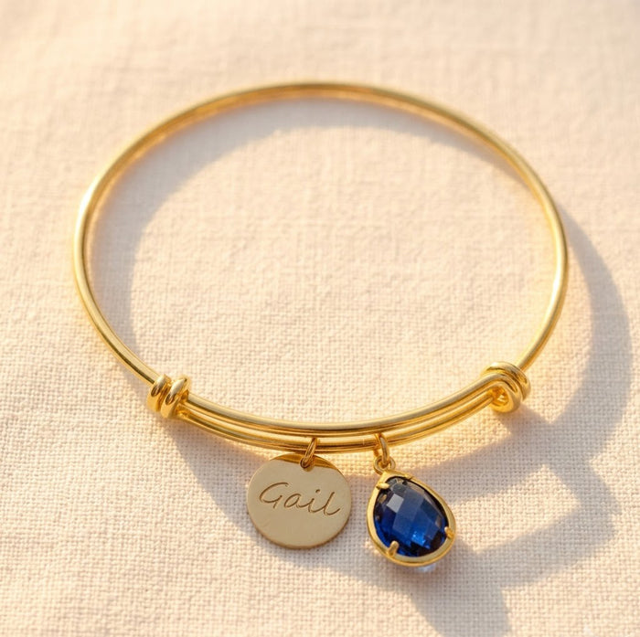 Personalized birthstone bangle bracelet with engraved name disc charm and blue teardrop stone