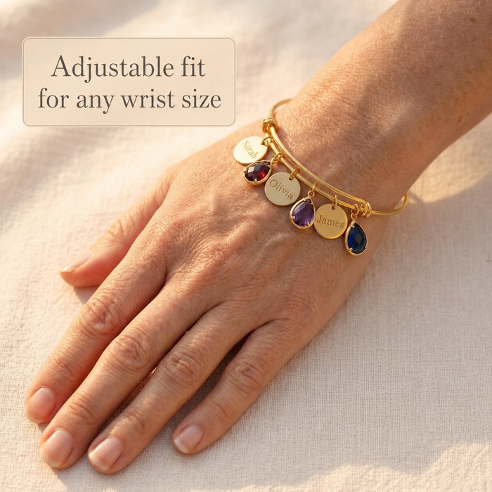 Adjustable birthstone bangle bracelet worn on wrist with name charms and gemstones