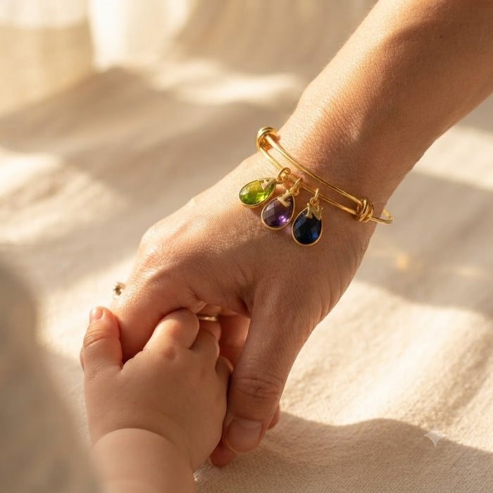 Custom birthstone bracelet for mom with teardrop gemstone charms and gold initials.