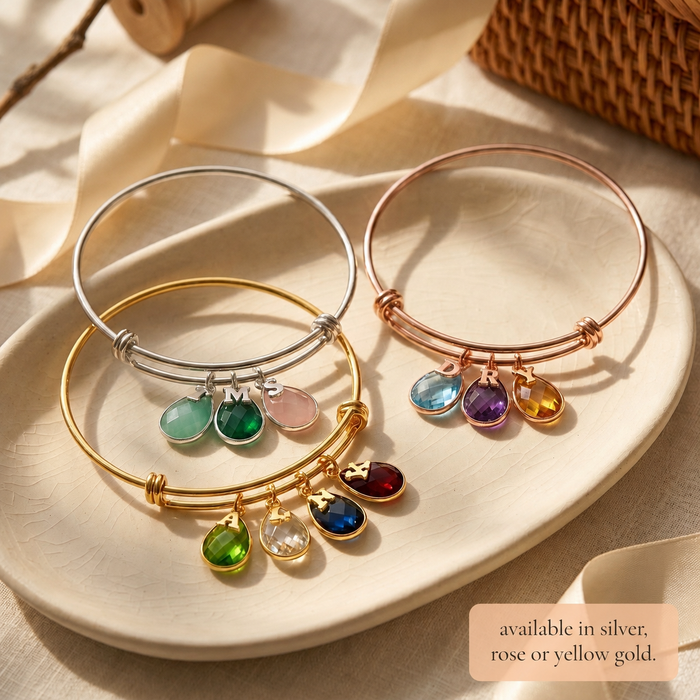 Silver, rose gold, and yellow gold birthstone bangle bracelet options.
