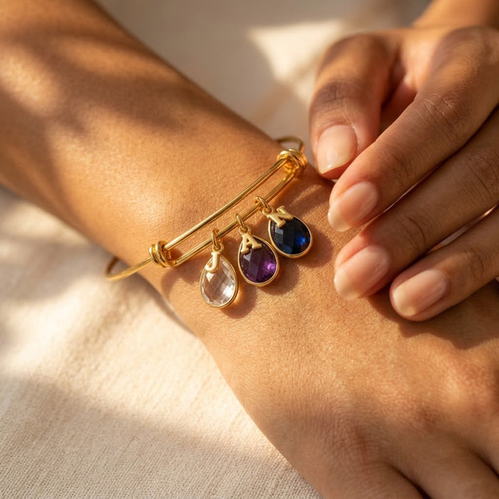 Personalized family bracelet with child’s hand touching mom’s wrist.