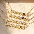 Personalized birthstone bar necklaces with engraved names and colorful gemstones in warm natural light.