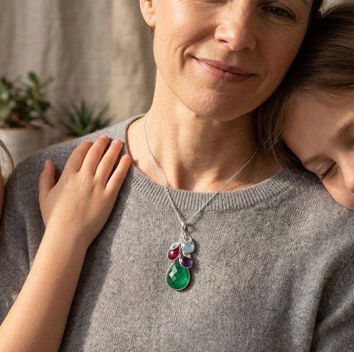 Woman wearing a personalized birthstone necklace with layered gemstone charms, a meaningful custom necklace representing children, grandchildren, or family members.