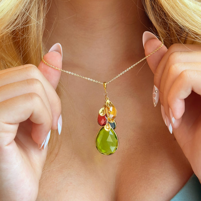 Custom birthstone initial charm necklace for mom in gold — cluster pendant with a large teardrop birthstone and three smaller teardrop gems paired with tiny initial tags, personalized family necklace on a delicate chain; meaningful Christmas, Mother’s Day or birthday gift.
