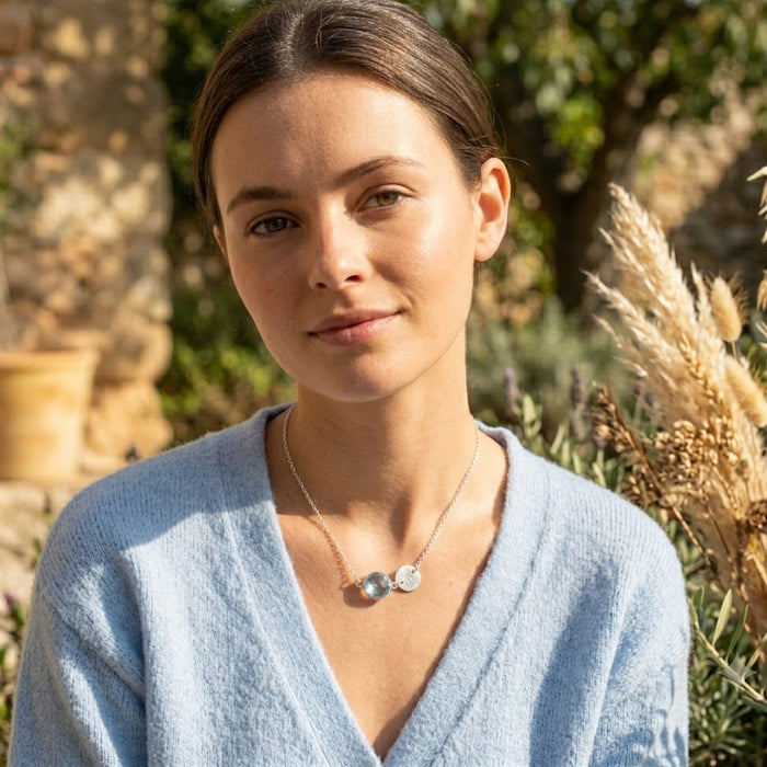 Blue topaz December birthstone necklace with custom letter charm on gold chain.
