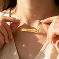 Personalized clear quartz bar necklace with engraved name Heather shown on model